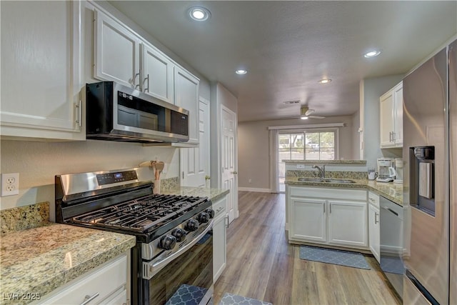 278 Star Cluster Cir, Las Vegas, NV 89145 - kitchen featuring appliances with stainless steel finishes, recessed lighting, light wood-type flooring, white cabinets, and a ceiling fan