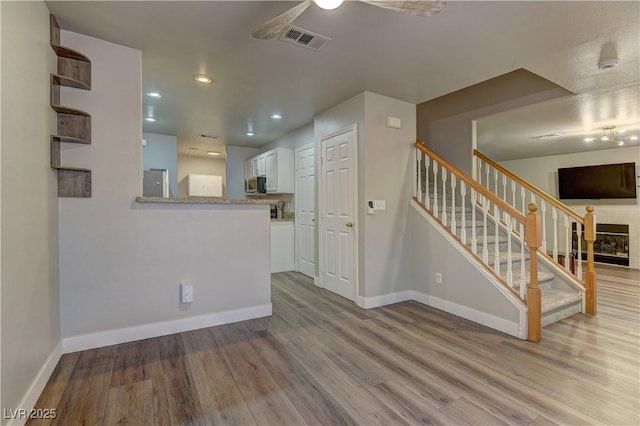 278 Star Cluster Cir, Las Vegas, NV 89145 - unfurnished living room featuring a ceiling fan, wood finished floors, stairs, and recessed lighting