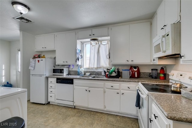 225 Pecos Way, Las Vegas, NV 89121 - kitchen featuring white appliances, washer / dryer, and white cabinets