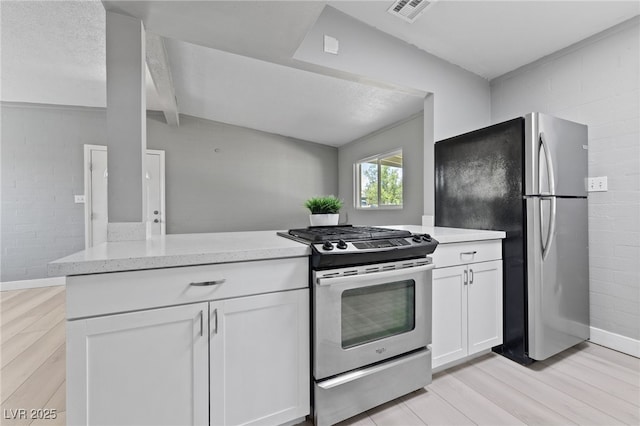 104 Stanford St, Las Vegas, NV 89107 - kitchen featuring appliances with stainless steel finishes, light wood finished floors, white cabinets, beam ceiling, and light stone countertops