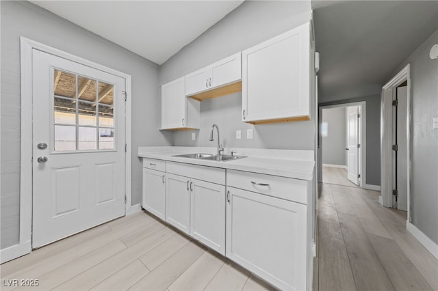 104 Stanford St, Las Vegas, NV 89107 - kitchen with light wood-style floors, light countertops, and white cabinets