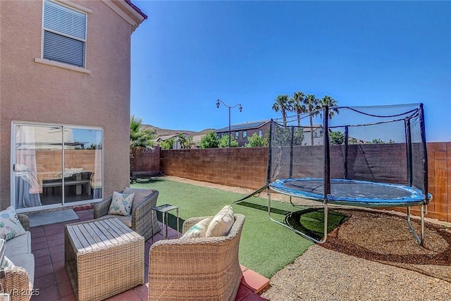 554 Haunts Walk Ave, Las Vegas, NV 89178 - fenced backyard with a trampoline, an outdoor living space, and a patio area