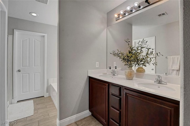 554 Haunts Walk Ave, Las Vegas, NV 89178 - bathroom featuring double vanity, a garden tub, and wood finished floors