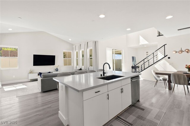 3058 Casarano Ct, Henderson, NV 89044 - kitchen featuring dishwasher, vaulted ceiling, light wood finished floors, light countertops, and a center island with sink