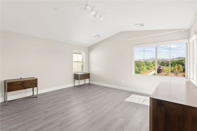 3058 Casarano Ct, Henderson, NV 89044 - empty room featuring vaulted ceiling, track lighting, and light wood-style floors