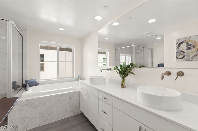 3058 Casarano Ct, Henderson, NV 89044 - full bath featuring a bath, double vanity, a stall shower, wood finished floors, and recessed lighting