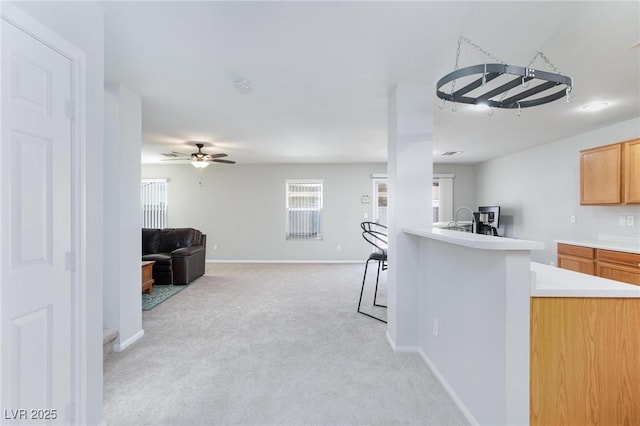 700 Red Bark Ln, Henderson, NV 89011 - kitchen featuring a ceiling fan, light carpet, light countertops, open floor plan, and a peninsula
