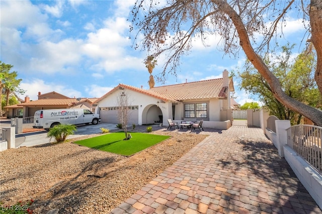 327 Fuente Dr, Henderson, NV 89014 - mediterranean / spanish house with driveway, a garage, stucco siding, a tiled roof, and a gate