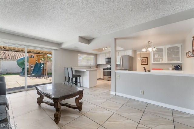 327 Fuente Dr, Henderson, NV 89014 - living room featuring a textured ceiling, a chandelier, and light tile patterned floors