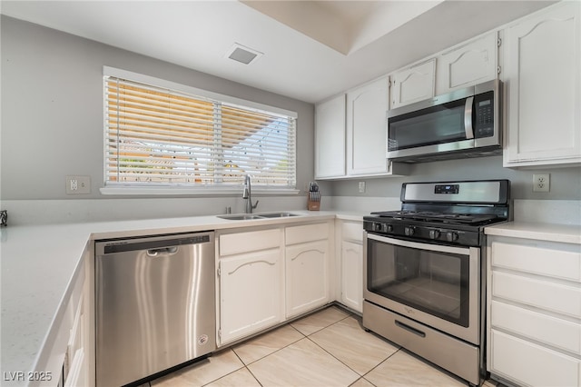 327 Fuente Dr, Henderson, NV 89014 - kitchen featuring stainless steel appliances, light tile patterned flooring, light countertops, and white cabinetry