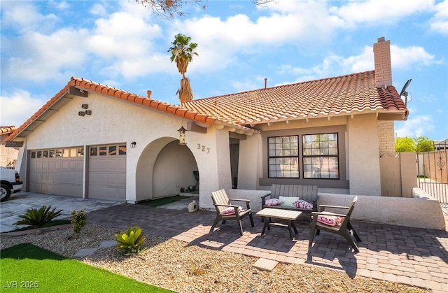 327 Fuente Dr, Henderson, NV 89014 - view of front of home with a garage, a tile roof, an outdoor hangout area, driveway, and stucco siding