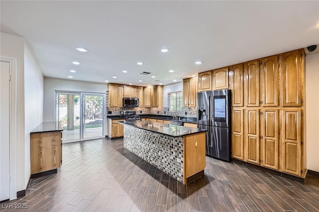 3557 Wayne Cir, Las Vegas, NV 89121 - kitchen featuring fridge with ice dispenser, stainless steel microwave, range, dark countertops, and a kitchen island