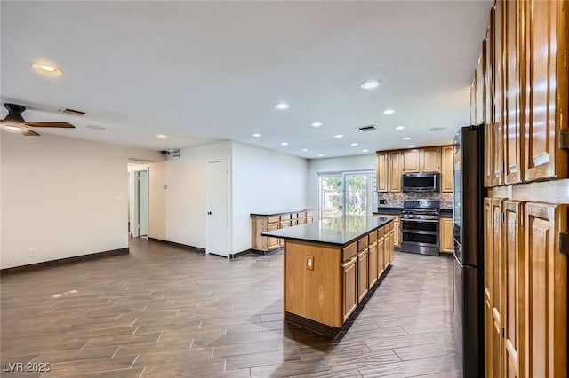 3557 Wayne Cir, Las Vegas, NV 89121 - kitchen with appliances with stainless steel finishes, dark countertops, dark wood-style floors, recessed lighting, and tasteful backsplash