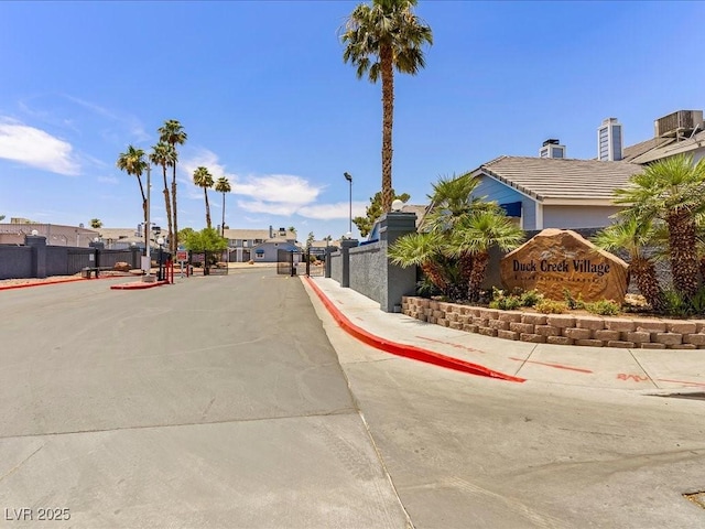 5861 Medallion Dr Unit 202, Las Vegas, NV 89122 - view of asphalt road with sidewalks, curbs, a gated entry, and street lighting