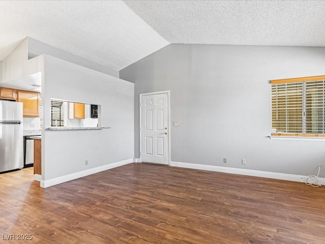 5861 Medallion Dr Unit 202, Las Vegas, NV 89122 - unfurnished living room with vaulted ceiling, wood finished floors, and a textured ceiling