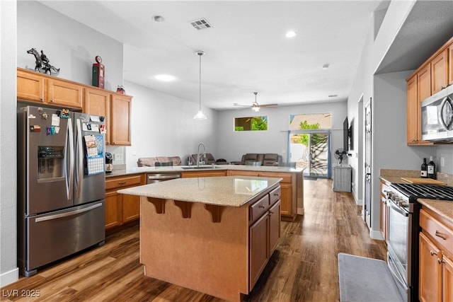 4212 Helens Pouroff Ave, North Las Vegas, NV 89085 - kitchen featuring appliances with stainless steel finishes, a peninsula, open floor plan, dark wood-style floors, and recessed lighting
