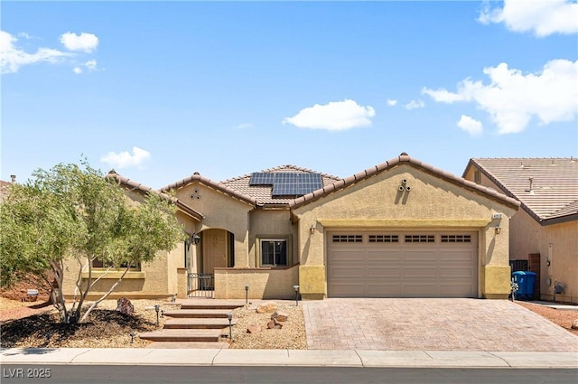 4212 Helens Pouroff Ave, North Las Vegas, NV 89085 - mediterranean / spanish house with a garage, stucco siding, roof mounted solar panels, decorative driveway, and a tiled roof
