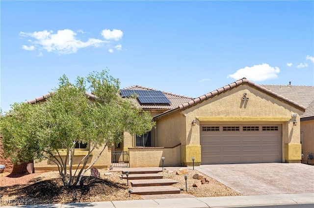 4212 Helens Pouroff Ave, North Las Vegas, NV 89085 - view of front of house with solar panels, an attached garage, stucco siding, driveway, and a tiled roof