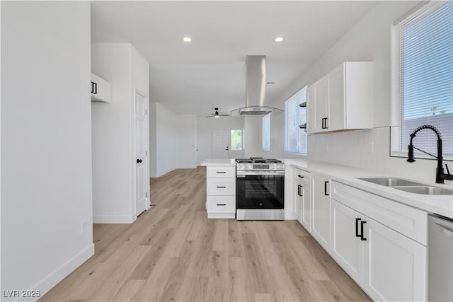 8944 W Rochelle Ave, Las Vegas, NV 89147 - kitchen with appliances with stainless steel finishes, island exhaust hood, white cabinetry, light wood-style floors, and a peninsula