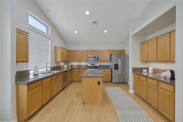 5512 Goldbrush St, Las Vegas, NV 89130 - kitchen with stainless steel appliances, a center island, light wood-type flooring, dark stone counters, and recessed lighting