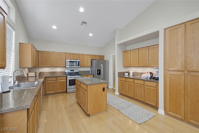 5512 Goldbrush St, Las Vegas, NV 89130 - kitchen with appliances with stainless steel finishes, light wood-style floors, a kitchen island, dark stone counters, and high vaulted ceiling