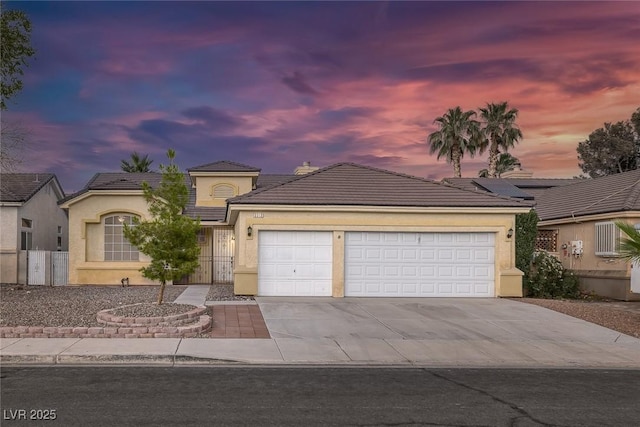 5512 Goldbrush St, Las Vegas, NV 89130 - view of front of house with a garage, concrete driveway, a tile roof, and stucco siding