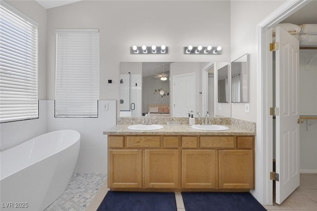 5512 Goldbrush St, Las Vegas, NV 89130 - full bath with a soaking tub, double vanity, tile patterned floors, a ceiling fan, and wainscoting