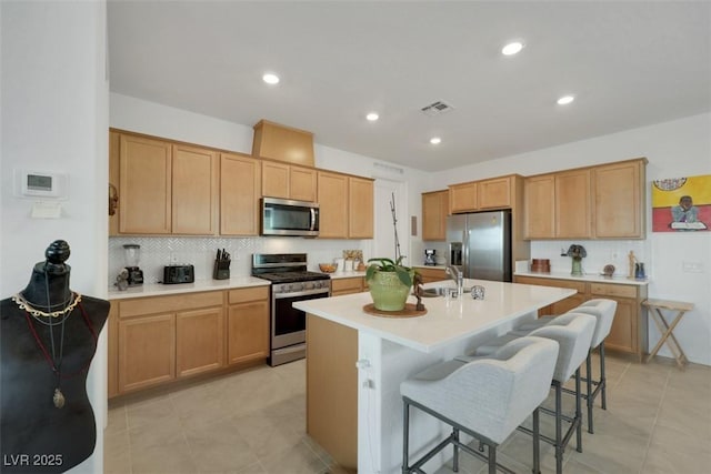 2261 Cold Canyon Ave, North Las Vegas, NV 89086 - kitchen featuring appliances with stainless steel finishes, decorative backsplash, light countertops, a kitchen breakfast bar, and recessed lighting
