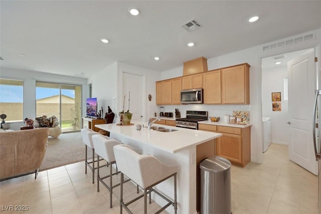 2261 Cold Canyon Ave, North Las Vegas, NV 89086 - kitchen featuring stainless steel appliances, open floor plan, light tile patterned flooring, light countertops, and a kitchen bar
