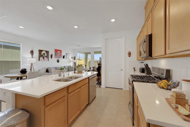 2261 Cold Canyon Ave, North Las Vegas, NV 89086 - kitchen with appliances with stainless steel finishes, light countertops, open floor plan, a center island with sink, and tasteful backsplash