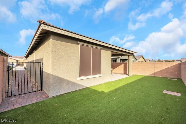 2261 Cold Canyon Ave, North Las Vegas, NV 89086 - rear view of house with stucco siding, a fenced backyard, a gate, and a patio area