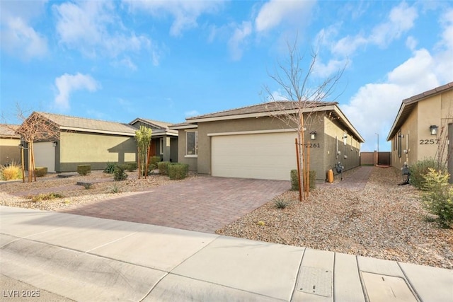 2261 Cold Canyon Ave, North Las Vegas, NV 89086 - view of front facade featuring stucco siding, an attached garage, and decorative driveway
