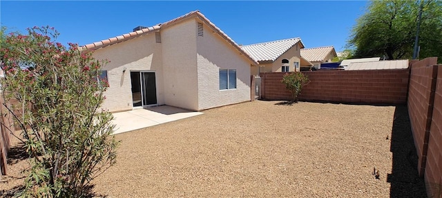 6615 Elk Creek Ln, Las Vegas, NV 89156 - rear view of house with stucco siding, a fenced backyard, a tile roof, and a patio area