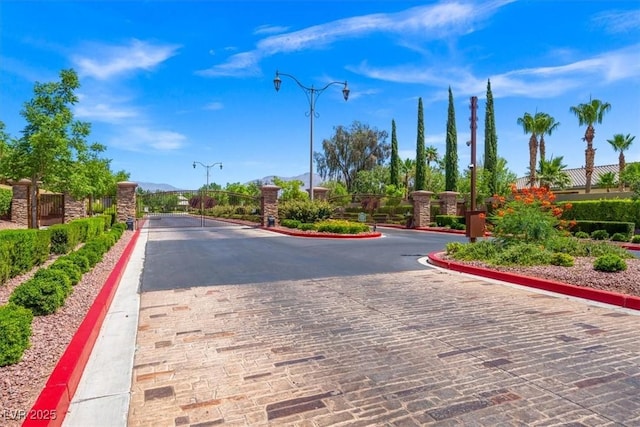 7286 Mount Kearsarge St, Las Vegas, NV 89131 - view of decorative road with a gate, curbs, a gated entry, and street lighting