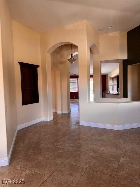 5005 Wild Thyme Ave, Las Vegas, NV 89131 - unfurnished living room featuring arched walkways and tile patterned flooring