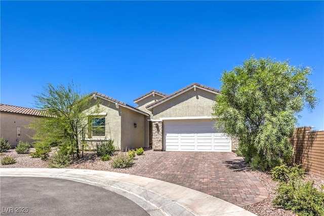 879 Klamath Springs St, Henderson, NV 89011 - view of front facade with stucco siding, a garage, decorative driveway, and stone siding