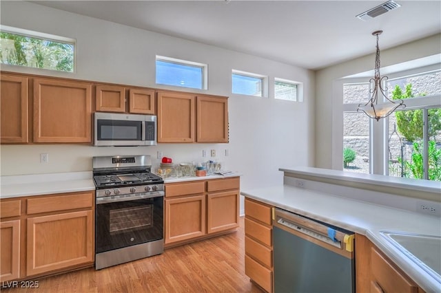 2413 Rockford St, Las Vegas, NV 89134 - kitchen with appliances with stainless steel finishes, light wood-type flooring, light countertops, and hanging light fixtures