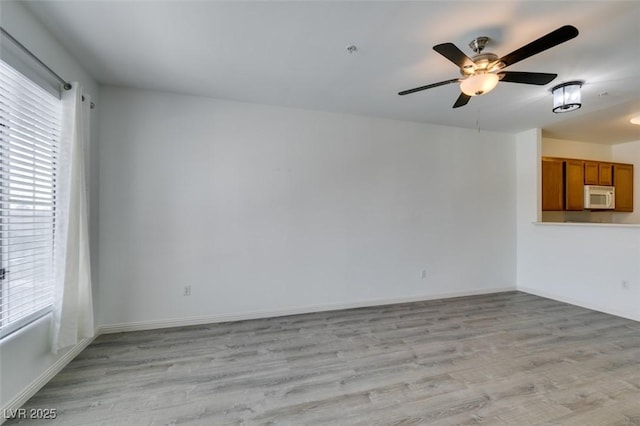 7163 S Durango Dr Unit 302, Las Vegas, NV 89113 - unfurnished living room featuring plenty of natural light, light wood-style flooring, and ceiling fan