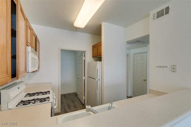 7163 S Durango Dr Unit 302, Las Vegas, NV 89113 - kitchen featuring white appliances, brown cabinetry, wood finished floors, and light countertops