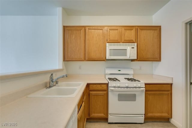 7163 S Durango Dr Unit 302, Las Vegas, NV 89113 - kitchen with white appliances, light countertops, light wood-style floors, and brown cabinetry
