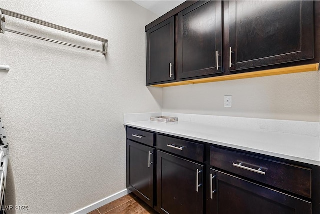 7017 Pearl Hilltop Ct, Las Vegas, NV 89148 - laundry room featuring tile patterned flooring, a textured wall, and cabinet space