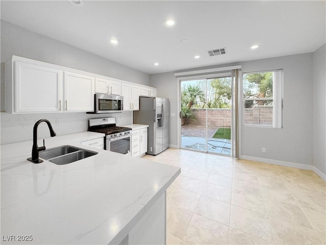 3532 Mountain Park St, Las Vegas, NV 89129 - kitchen with stainless steel appliances, white cabinets, recessed lighting, light stone counters, and light tile patterned flooring