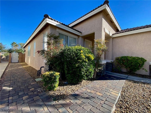 3532 Mountain Park St, Las Vegas, NV 89129 - view of side of home with a gate, stucco siding, and a tiled roof