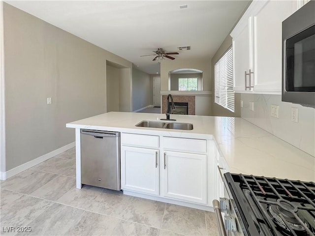 3532 Mountain Park St, Las Vegas, NV 89129 - kitchen with stainless steel appliances, a peninsula, a ceiling fan, white cabinetry, and open floor plan
