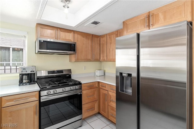 2152 High Dunes Ln, Laughlin, NV 89029 - kitchen featuring appliances with stainless steel finishes, light countertops, light tile patterned floors, and a tray ceiling