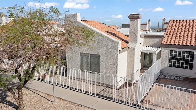 2152 High Dunes Ln, Laughlin, NV 89029 - view of home's exterior featuring a tile roof, stucco siding, and a chimney