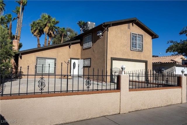 1340 Lucky St, Las Vegas, NV 89104 - view of front of home featuring a garage, stucco siding, a fenced front yard, and concrete driveway