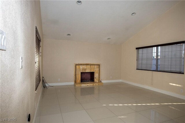 1340 Lucky St, Las Vegas, NV 89104 - unfurnished living room with tile patterned flooring, lofted ceiling, and a fireplace