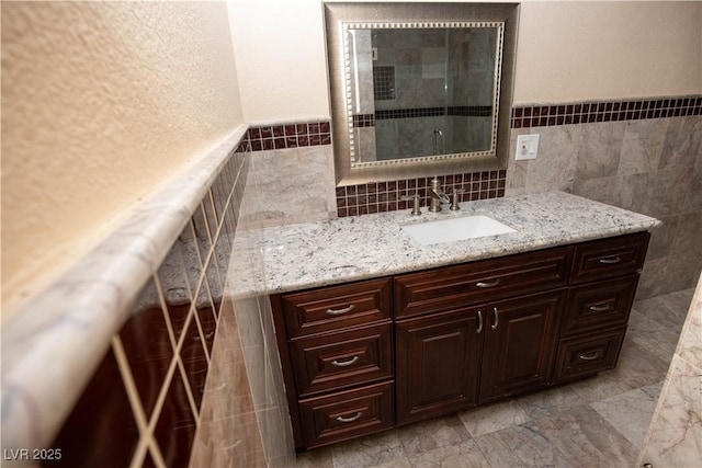 1340 Lucky St, Las Vegas, NV 89104 - bathroom with tile walls, vanity, and a wainscoted wall