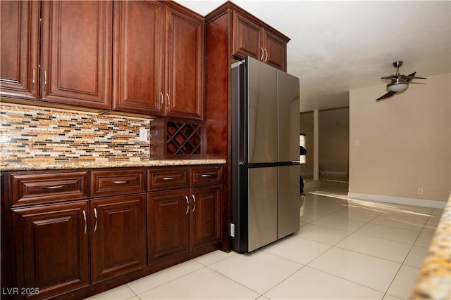 1340 Lucky St, Las Vegas, NV 89104 - kitchen with freestanding refrigerator, light tile patterned floors, ceiling fan, backsplash, and light stone countertops